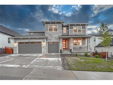 Charming two-story home featuring a three-car garage and inviting front porch at 2775 Morningbird Ln, Castle Rock, CO 80109