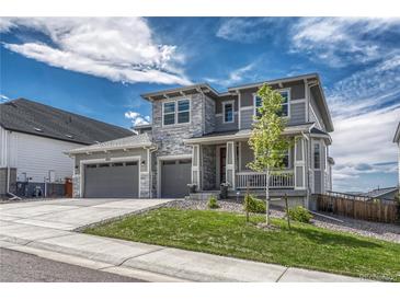 Charming two-story home with a three-car garage, stone accents, and a welcoming front porch at 2775 Morningbird Ln, Castle Rock, CO 80109