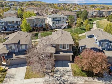 Inviting suburban home featuring a manicured lawn and mature trees on a sunny day at 10657 Cherrybrook Cir, Highlands Ranch, CO 80126
