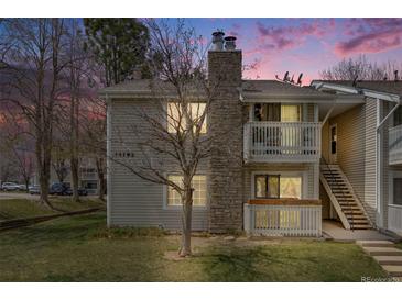 Charming condo with a stone chimney, two balconies, a well-kept lawn, and stairs to the upper level at 14192 E Colorado Dr # 102, Aurora, CO 80012