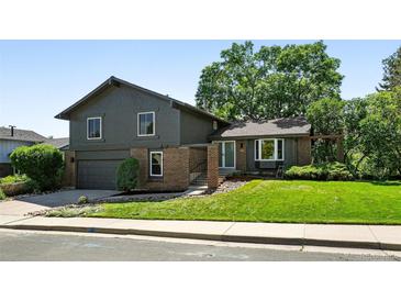 Charming two-story home featuring a well-manicured lawn, mature trees, and a covered front entrance at 5616 S Kenton Ct, Englewood, CO 80111