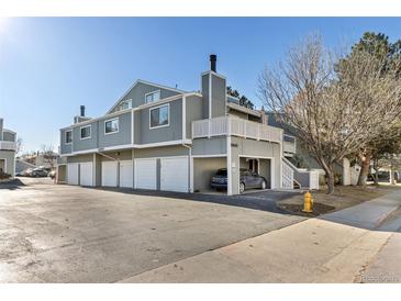 Gray two-story townhouse with white trim, garage, and a car parked underneath the second story balcony at 6600 E Mississippi Ave # 7, Denver, CO 80224
