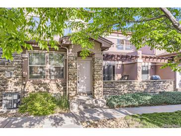 Inviting townhouse entrance with stone accents and a charming covered patio area at 15501 E 112Th Ave # 28E, Commerce City, CO 80022