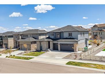 Beautiful two-story home with stone accents, manicured lawn, and a two-car garage at 7240 S White Crow Way, Aurora, CO 80016