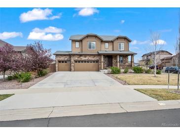 Charming two-story home with brick accents, a well-manicured lawn, and a spacious three car driveway at 224 S Jackson Gap Way, Aurora, CO 80018