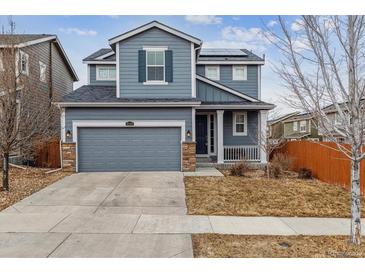 Two-story house with gray siding, a two-car garage, and a well-maintained lawn at 15162 Jakarta Cir, Parker, CO 80134