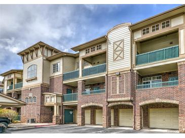 A beautiful brick building with tan siding, balconies, and individual garages with archways at 3854 S Dayton Way # 308, Aurora, CO 80014