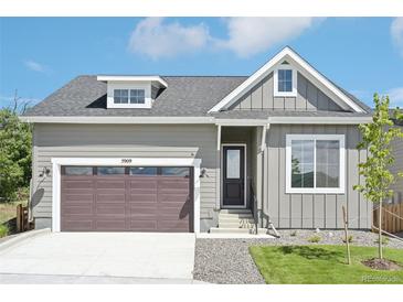 Charming home featuring an attached garage, a manicured lawn, and a classic exterior design at 5909 S Platte Canyon Dr, Littleton, CO 80123