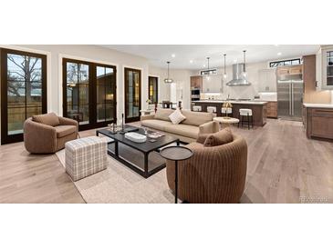 Open-concept living room with modern furnishings and abundant natural light flowing into the kitchen at 1149 S Madison St, Denver, CO 80210