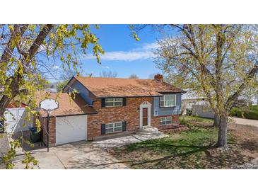 Charming brick two-story home with attached garage, well-maintained lawn, and mature trees at 11506 Fowler Dr, Northglenn, CO 80233