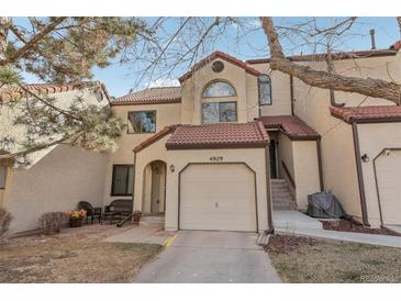 Charming townhome featuring a stucco facade, red tile roof, and attached garage at 4929 W 73Rd Ave, Westminster, CO 80030