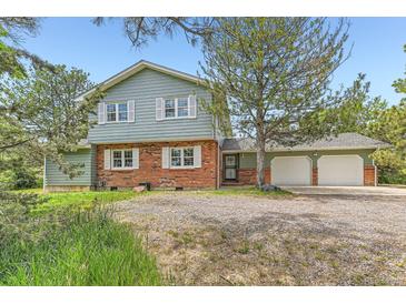 Charming two-story home featuring a brick facade, white shutters, and a spacious three-car garage at 6351 S Andes Pl, Centennial, CO 80016