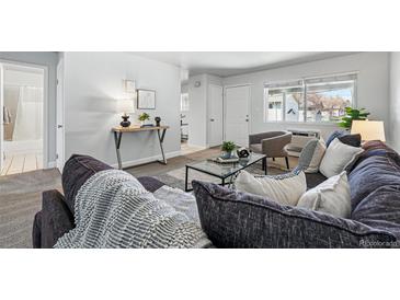 Inviting living room features a comfortable couch, lots of pillows and plenty of natural light at 2595 S Sheridan Blvd # 20, Denver, CO 80227