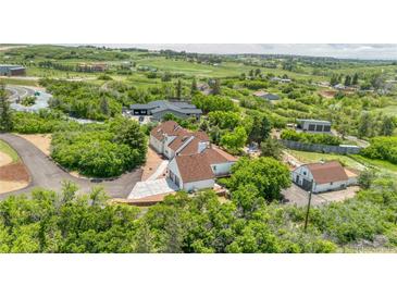 Stunning aerial view of a home and surrounding landscape with mature trees and a long driveway at 9053 Clydesdale Rd, Castle Rock, CO 80108