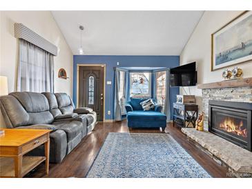 Cozy living room features a fireplace, bay window, and comfortable seating at 961 S Evanston Cir, Aurora, CO 80012