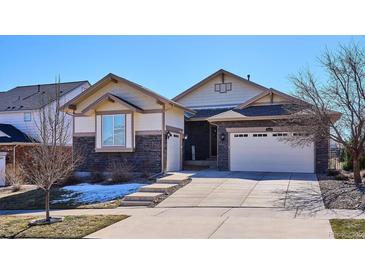 Charming home with a stone facade, three-car garage, and a well-manicured lawn at 6019 S Little River Way, Aurora, CO 80016