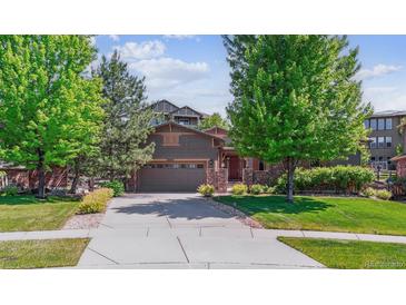 Charming two-story home with a well-manicured lawn, mature trees, and a spacious driveway leading to an attached two-car garage at 25402 E Glasgow Pl, Aurora, CO 80016
