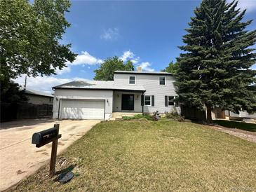 Charming two-story home featuring a well-maintained lawn, attached garage, and classic curb appeal at 7431 Webster St, Arvada, CO 80003