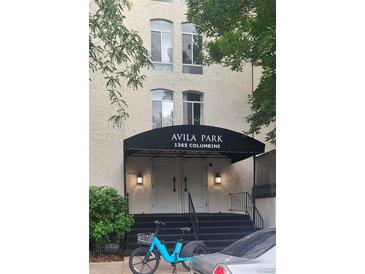 Building entrance with black awning, white double doors, and wrought iron railings at Avila Park, 1365 Columbine at 1365 Columbine St # 403, Denver, CO 80206