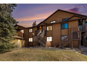 Charming condo exterior with wood siding, dual staircase entries, and well-maintained landscaping at 9077 W 88Th Cir, Denver, CO 80021