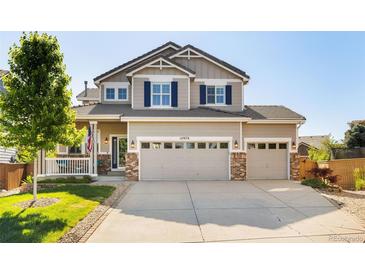 Charming two-story home featuring a three car garage, well-manicured lawn, and inviting front porch at 10978 Ashurst Ln, Highlands Ranch, CO 80130