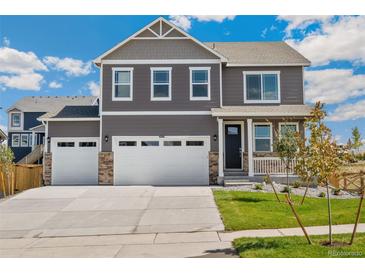 Inviting two-story home boasts a three-car garage, charming front porch, and well-manicured lawn at 14249 Beebalm Ave, Parker, CO 80134