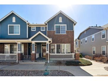 Charming two-story townhome with a brick facade and a cozy front porch at 16149 E Geddes Ln # 99, Aurora, CO 80016