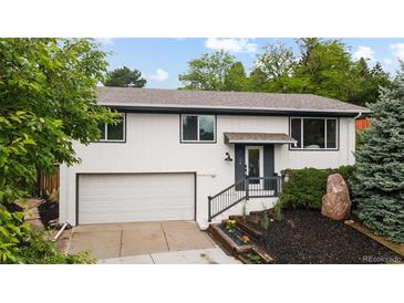 Charming two-story home featuring an attached garage and well-maintained landscaping at 13249 W Jewell Pl, Denver, CO 80228