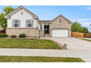 Charming two-story home with a well-manicured lawn, two-car garage, and inviting curb appeal at 4545 Oxbow Dr, Brighton, CO 80601