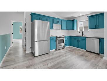 Bright kitchen featuring blue cabinets, stainless steel appliances, and sleek subway tile backsplash at 3470 W Walsh Pl, Denver, CO 80219
