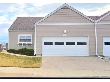 Tan two-car garage townhome with landscaping at 15555 E 40Th Ave # 118, Denver, CO 80239