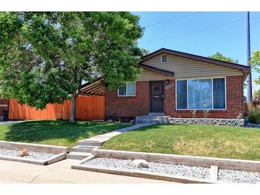 Charming red brick home with a well-maintained front yard and mature tree at 11085 Clarkson St, Northglenn, CO 80233