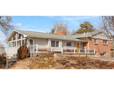 Charming single-story home with a brick facade, gray siding, and inviting front porch at 11845 W 30Th Pl, Lakewood, CO 80215