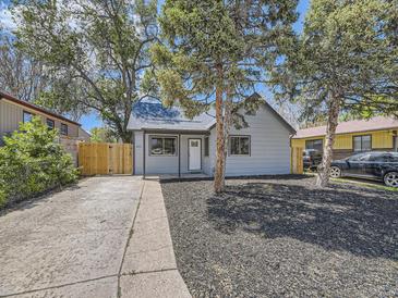 Charming single-story home with a well-maintained yard, inviting entrance, and mature trees at 655 S Osceola St, Denver, CO 80219