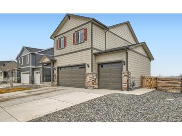 Two-story home with a 2-car garage with stone veneer and neutral color palette at 140 Racer St, Bennett, CO 80102