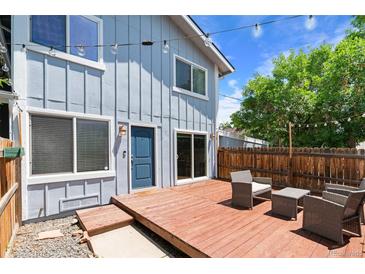 Inviting backyard with a wooden deck, outdoor seating, string lights, and a well-maintained fence at 2854 N Lowell Blvd, Denver, CO 80211