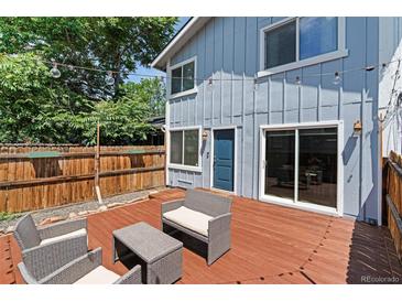 Inviting outdoor space with charming string lights, patio seating, and a well-maintained wood fence and deck at 2854 N Lowell Blvd, Denver, CO 80211