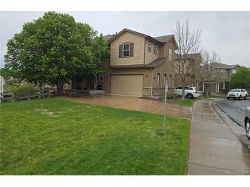 Inviting two-story home with a well-manicured lawn, attached garage, and mature trees at 11811 E Maplewood Ave, Englewood, CO 80111