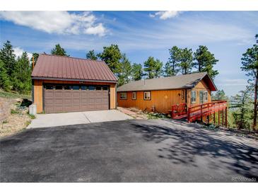 Cozy cabin home with a detached garage and beautiful mountain views from the elevated deck at 8624 S Doubleheader Ranch Rd, Morrison, CO 80465