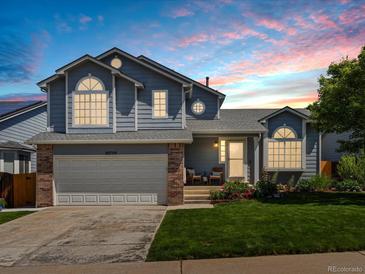 Charming two-story home featuring an attached garage, a manicured lawn, and beautiful landscaping at 20789 E Princeton Pl, Aurora, CO 80013