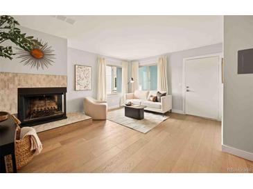 Spacious living room featuring a fireplace and white walls at 7946 Chase Cir # 112, Arvada, CO 80003