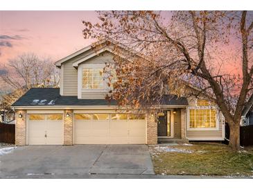 Two-story house with beige siding, three-car garage, and landscaping at 6716 W 97Th Cir, Broomfield, CO 80021