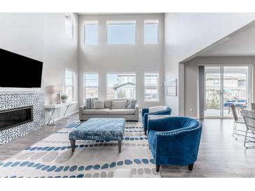 Bright living room with high ceilings, fireplace, comfortable seating, and many windows at 211 Luna Ct, Erie, CO 80516