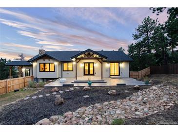 Beautifully landscaped home with a covered patio and well-maintained backyard at 24701 Us Hwy 40, Golden, CO 80401