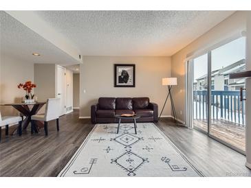 Spacious living room with fireplace and sliding glass door to deck at 1312 S Cathay Ct # 202, Aurora, CO 80017