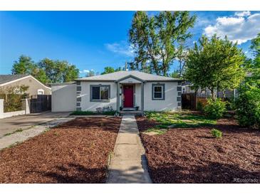 Charming single-story home featuring a red door, manicured lawn, and a concrete pathway at 2658 W 1St Ave, Denver, CO 80219