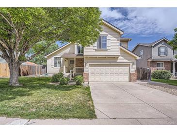 Charming two-story home featuring a well-manicured lawn and a spacious two car garage at 9882 Harris St, Thornton, CO 80229