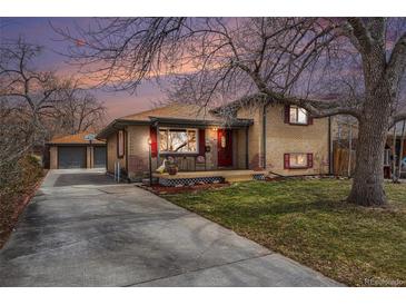 Charming brick home with a cozy front porch and a detached garage, nestled under a large tree at 7930 Quitman St, Westminster, CO 80030