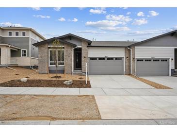 Charming single Gathering home featuring brick accents, a two car garage, and landscaping at 6615 N Nepal St, Aurora, CO 80019
