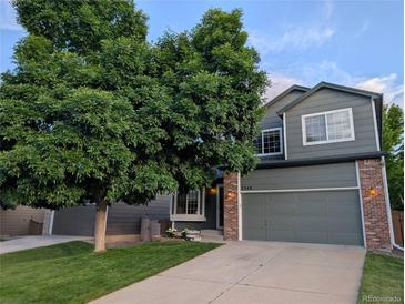 Charming two-story home with a mature shade tree and a well-maintained lawn at 2548 Foothills Canyon Ct, Highlands Ranch, CO 80129